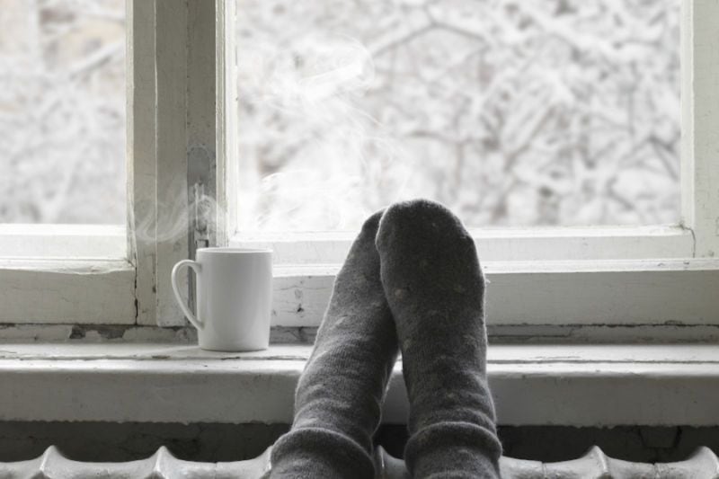 A person warms up inside. How Can I Make My Furnace Last Longer?||A woman with a pen ponders.