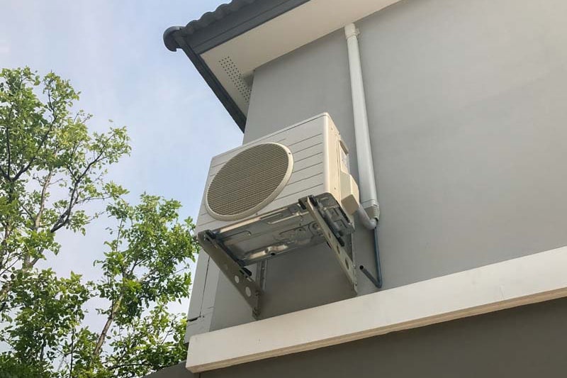 An air conditioner set in the side of a building | What Does AC SEER Mean? | Keep your AC Efficient | Maryville