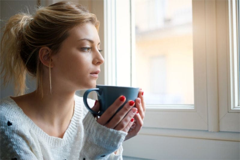 Sad girl portrait holding a cup of hot drink