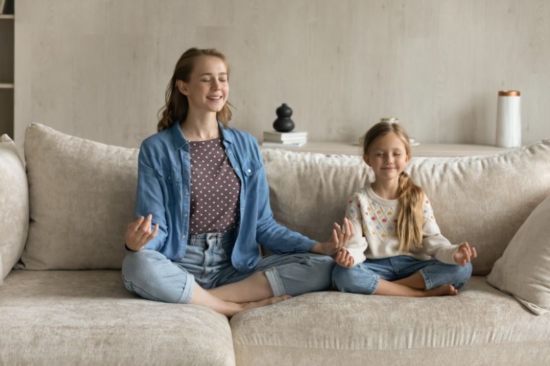 Image of two children sitting on couch. Air Conditioning Noise Concerns.